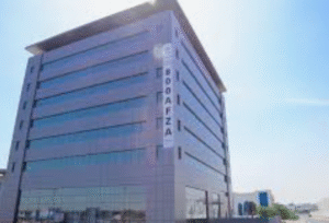 Ajman Free Zone modern office building with glass facade under clear blue sky